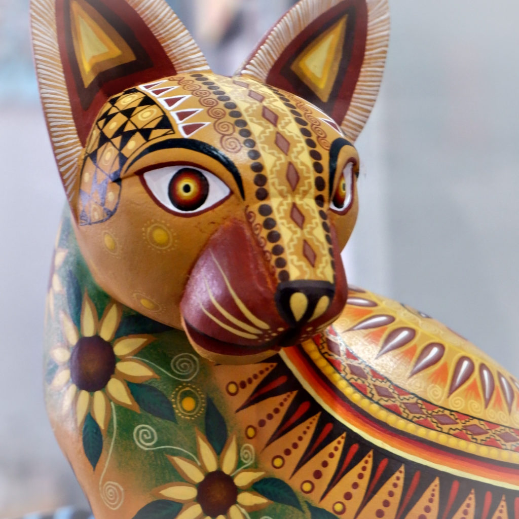 Intricately hand painted wooden sculpture of a cat.